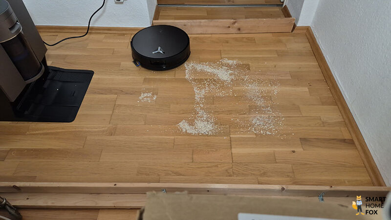 Der ECOVACS DEEBOT X11 saugt Schmutz auf glattem Hartboden im Test.